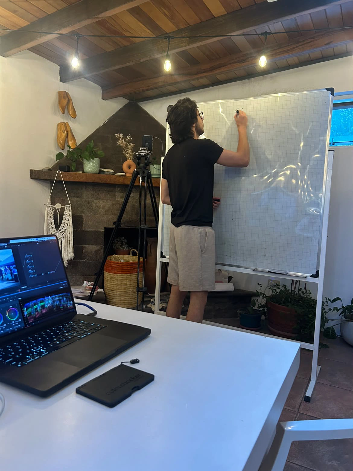 Vichortega explicando en la pizarra, junto a una computadora con DaVinci Resolve.